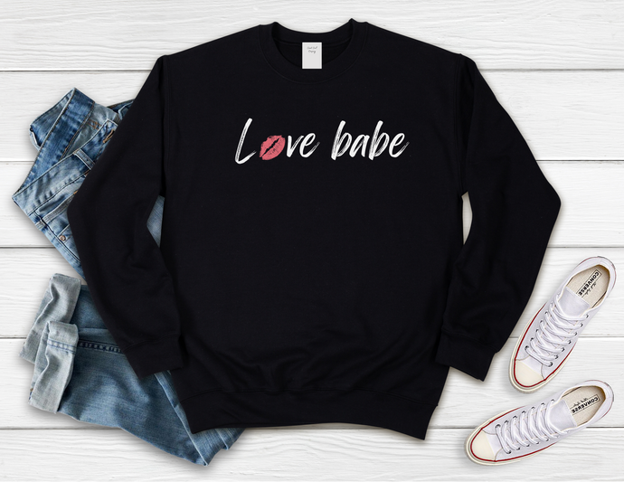 Softest Crewneck Sweatshirt. Designed to elevate your vibe to help you live your intention. We see you strive to surround yourself in love.     You can consciously create your internal state when you practice living with love. Choosing peace, joy, compassion, gratitude and mindfulness,  over and over and over, babe. Practice living with love, babe. For yourself and others, and radiate the loving human that you are. Black crewneck sweatshirt with white love babe print and pink lips for the o in love.